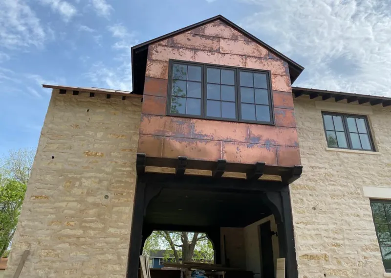 Copper metal panel facade on a stone building for Roof Repair in Honeygo