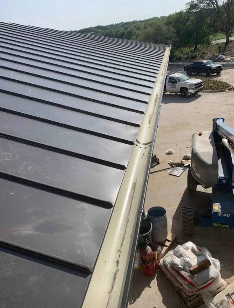 Standing seam panel and gutter detail on a metal roofing jobsite in Honeygo